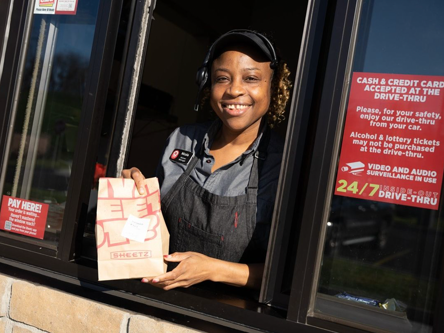 fast food worker handing food through a window